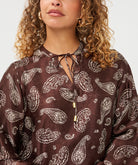Blouse Esqualo à imprimé paisley et bordure — détail du col à nouer et du motif sur mannequin