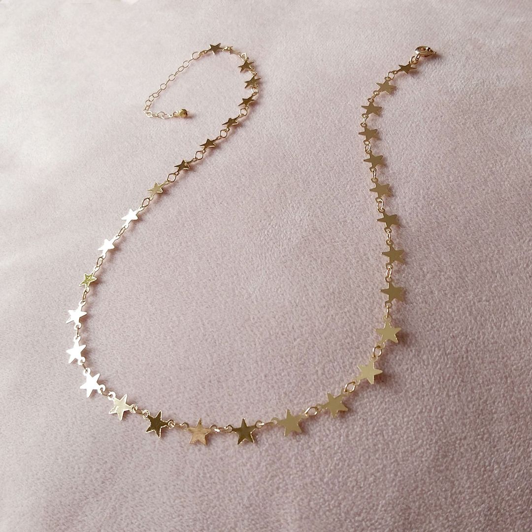 collier en or rose avec des petites étoiles étincelantes et une chaîne ajustable